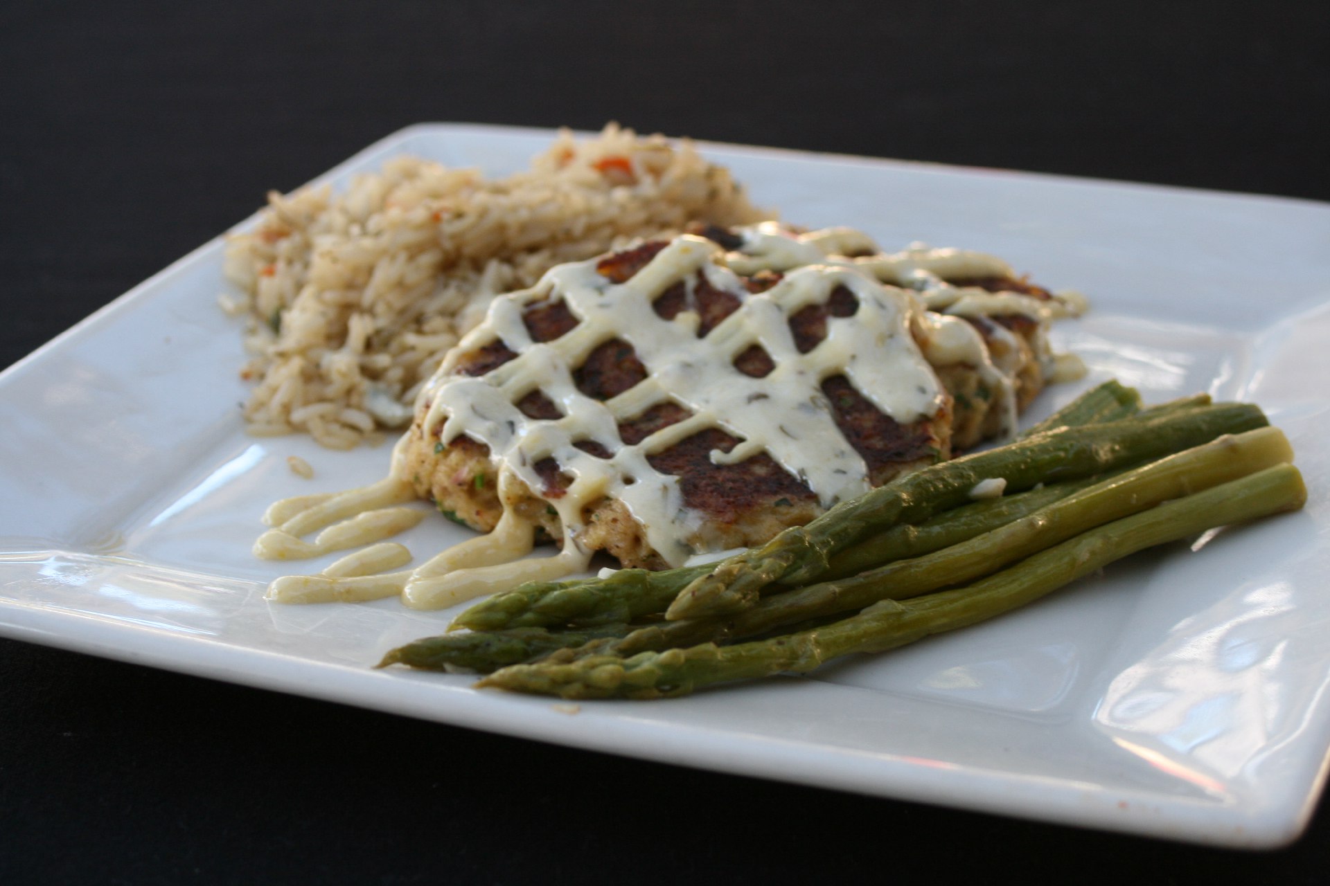 crab cakes topped with remoulade sauce and house rice